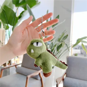Macro view of a cute plush green dinosaur keychain with soft texture and silver ring
