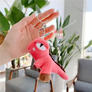 Close-up of pink plush dinosaur keychain with soft texture and silver lobster clasp