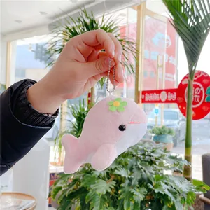 Detailed view of pink dolphin plush keychain with green flower and silver bead chain