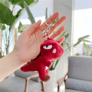 Close-up of red plush T-Rex dinosaur keychain with soft texture and metallic clasp detail