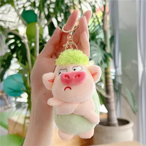 Detailed close-up of a cute plush pig keychain with green hair in a bright indoor setting