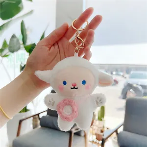 Close-up of cute white sheep plush keychain with pink crochet bag and golden metal clip