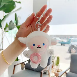 Macro view of cute plush sheep keychain with soft fur, pink floral bag, and metal clip