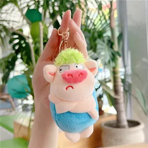 Detailed view of a plush pig keychain with green fluffy hair and a blue body for bags