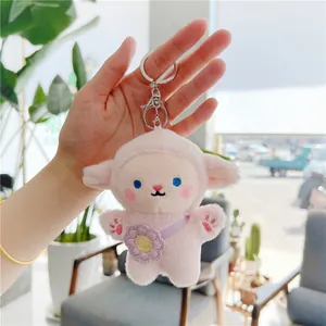 Close-up of a cute pink sheep plush keychain with soft fur and purple flower bag detail