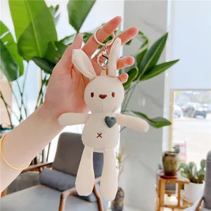 Detailed view of cream plush bunny keychain with embroidered heart and silver metal clasp