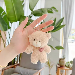 Detail of light brown plush teddy bear keychain with pink heart and silver ring