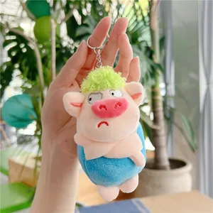 Detailed view of pink plush pig keychain with green hair and silver metal ring
