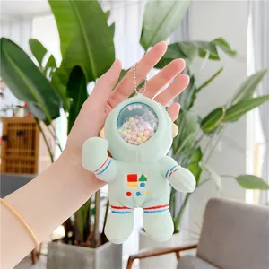 Detail eines mintgrünen Astronauten-Plüschanhängers mit Perlen und Stickereien am Rucksack