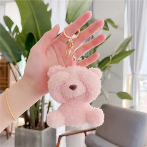 Pink plush teddy bear keychain with golden metal ring and soft textured fleece fabric