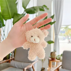 Close-up of fluffy beige teddy bear keychain accessory with soft plush fur and metal ring