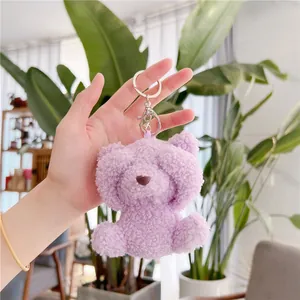 Detail of a soft purple plush teddy bear charm with a metal keychain and lobster clasp