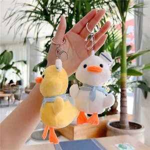Detail of plush duck keychains with blue scarves and lobster clasp on a bag