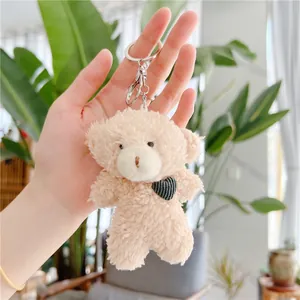 Plush teddy bear keychain with black heart in hand, soft cream stuffed animal accessory