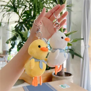 Detailed view of yellow and white plush duck pendants with sailor hats and blue scarves