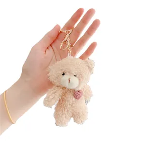 Plush brown teddy bear keychain with pink heart detail and golden lobster clasp