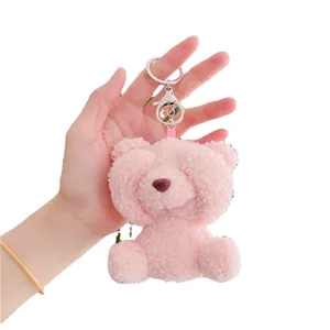 Pink teddy bear plush keychain with silver lobster clasp shown held in hand