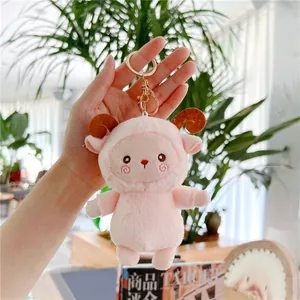 Close-up of pink plush lamb keychain with golden metal clasp and embroidery