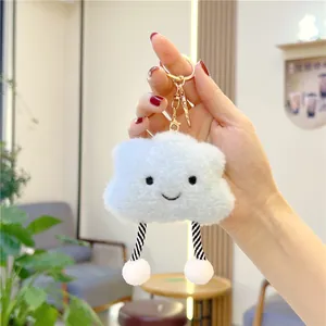 Detail of soft plush cloud keychain with embroidered smile and striped dangling legs