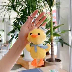 Detailed close-up of a plush yellow duck keychain with a sailor hat and blue scarf