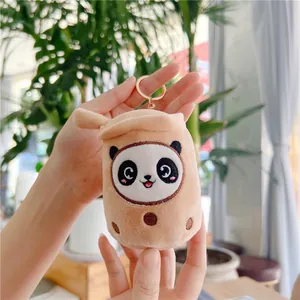 Macro van de panda melkthee pluche hanger met bruine vacht en een gouden sleutelring