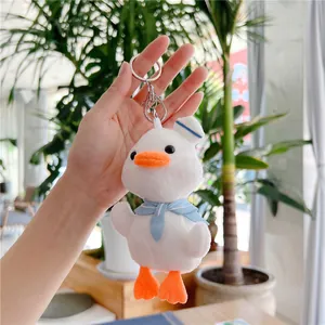 Detail of cute plush duck keychain in sailor outfit with soft white fur and metal clasp