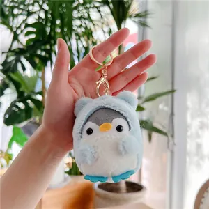 Close-up of cute penguin plush keychain with a light blue bear-ear hood and gold metal clasp
