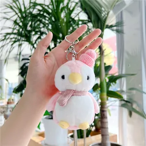 Close-up of pink plush penguin keychain with a knit hat and silver metal ring