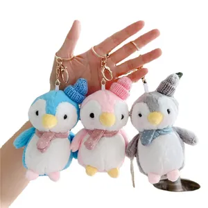 Cute plush penguin keychains in blue, pink, and grey with knit hats and scarves