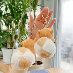 Detailed close-up of fluffy corgi butt plush keychains with soft white pompom tails