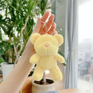 Close-up of yellow teddy bear plush keychain with soft fur and pink nose detail