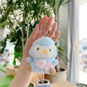 Detail of soft blue penguin plush keychain with pink bunny bag and silver chain