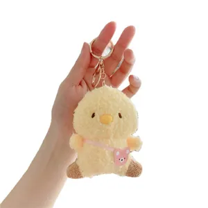 Cute yellow plush chick keychain featuring curly fleece material and mini pink bear bag