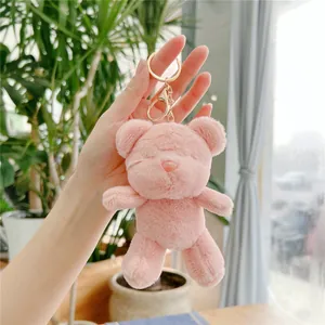 Close-up of a pink plush teddy bear keychain with soft fur and golden metal lobster clasp
