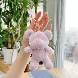 Detailed view of a purple plush bear keychain with golden metal ring and lobster clasp
