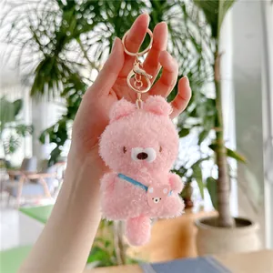 Detailopname van een roze pluche berenknuffel met tasje en gouden metalen sluiting