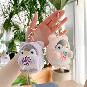 Detail of plush penguin keychains in purple bear and pink ice cream hoodies with gold clips