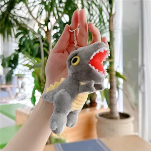 Close-up of grey and yellow plush dinosaur keychain with silver metal ring