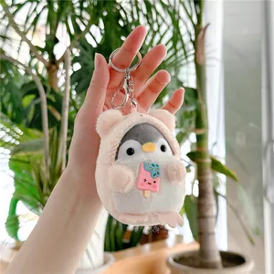 Close-up of plush penguin keychain wearing a pink bear hoodie and holding a popsicle