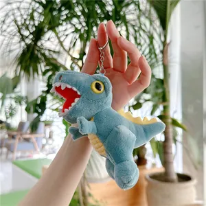 Close-up of a plush dinosaur keychain in blue with yellow fins and a metal clip
