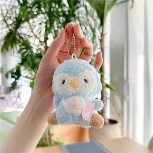 Detail van zachte blauwe pluche pinguïn sleutelhanger met roze konijntas en ketting