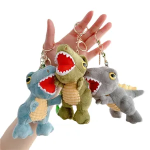 Three plush dinosaur keychains in blue green and grey with metallic gold ring