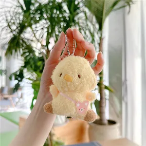 Detail van pluizige gele kuiken pluche hanger met een klein roze beer schoudertasje