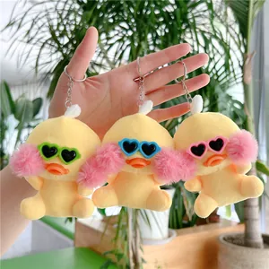 Three cute plush yellow duck keychains with colorful heart sunglasses in a hand