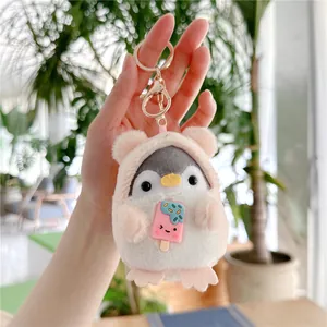 Detail of penguin plush keychain wearing pink bear hoodie with ice cream accessory