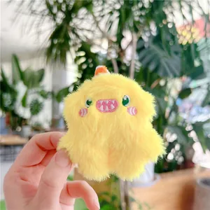 Detailed view of yellow plush monster keychain with fuzzy texture and cute embroidery