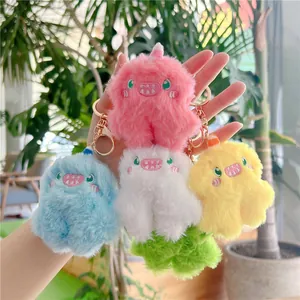 Set of five colorful monster plush keychains in pink, blue and yellow with gold hooks