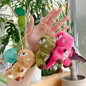 Plush dinosaur keychains in green, pink, and brown with gold metal lobster clips