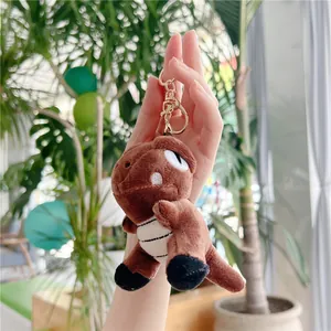 Brown dinosaur plush keychain with white striped belly and gold metal lobster clasp