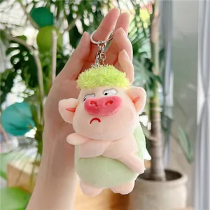 Close-up of cute plush pig pendant with green fuzzy hair and silver metal keychain